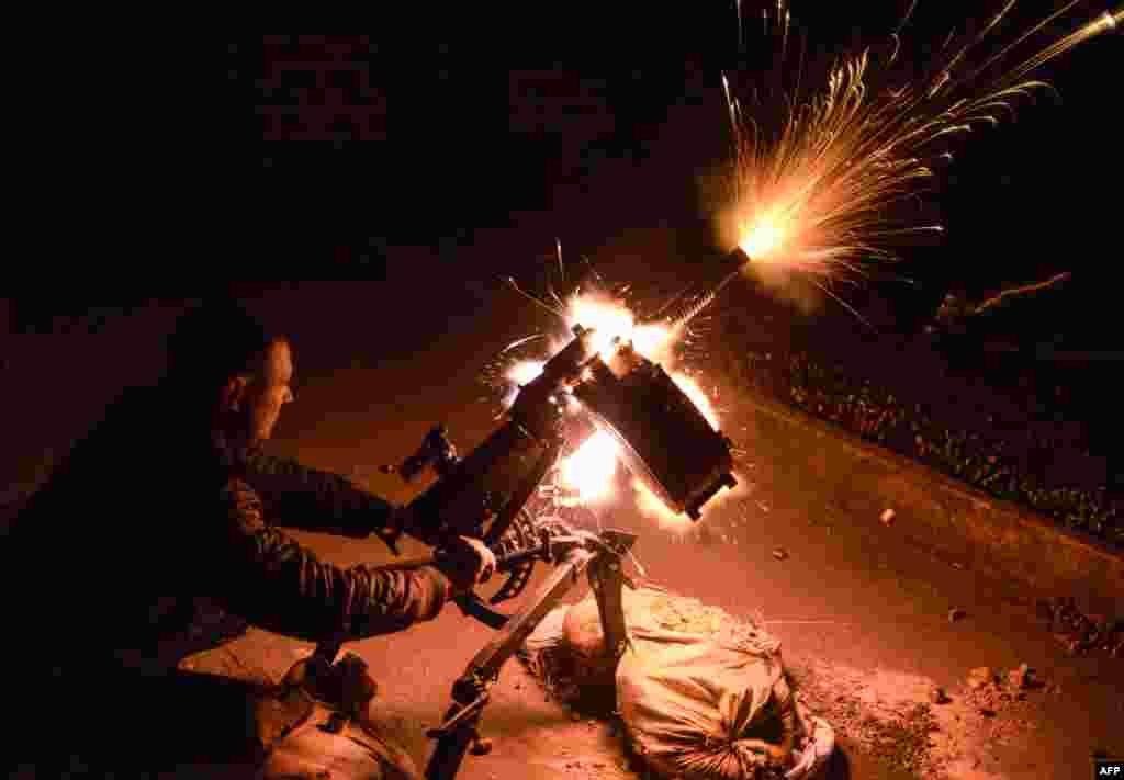 A Ukrainian serviceman shoots an automatic grenade launcher at position near the village of Peski, near Donetsk, on October 20. (AFP/Aleksey&nbsp;Chernyshev) 