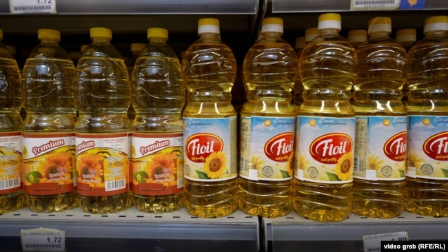 Shishe me vaj luledielli të ekspozuara në raftet e një dyqani ushqimor.