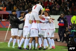 DÇ-2026-nın seçmə mərhələsi: İran futbolçuları Özbəkistanla oyunda qol sevincini bölüşürlər.