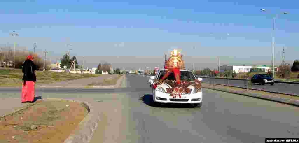 Aşgabadyň köçeleriniň birinden barýan toý maşyny.