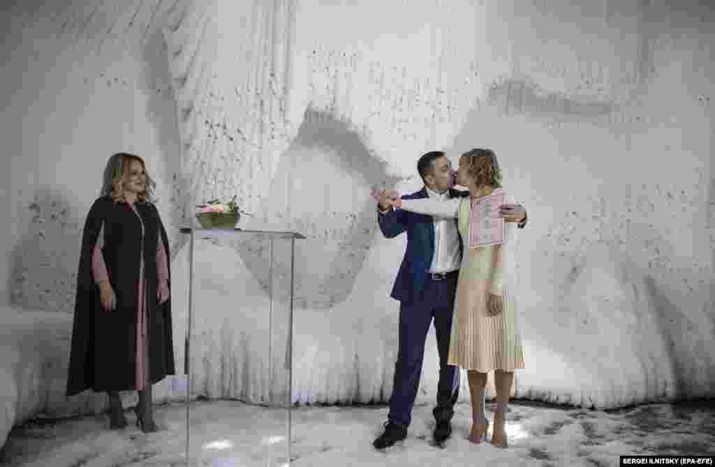 Dy të porsamartuar rusë puthen gjatë ceremonisë së tyre të martesës në një shpellë akulli në Parkun Zaryadye, në qendër të Moskës. (epa-EFE / Sergei Ilnitsky)