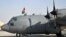 A member of the Afghan Air Force raises the national flag on top of a C-130 transport aircraft at Kabul's international airport on October 9, 2013.