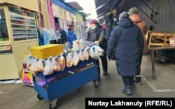 Продающая горячий чай и булочки женщина. Алматы, 24 декабря 2020 года.