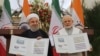 Indian Prime Minister Narendra Modi, right, with Iranian President Hassan Rouhani release a postal stamp commemorating growing economic and trade ties between the two nations in New Delhi, February 17, 2018