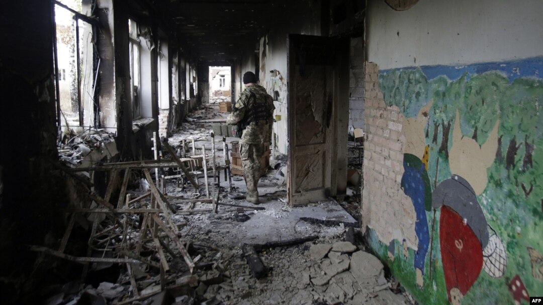 A Ukrainian serviceman walks through a destroyed school in the village of Pisky near Donetsk late last year.