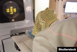 Пациент в маске для лучевой терапии с лазерными линиями для нацеливания на раковые клетки в головном мозге