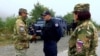 Një ushtare sllovene duke shikuar teksa një ushtar amerikan bisedon me një pjesëtarë të Policisë së Kosovës në Jarinjë. Fotografi nga arkivi.