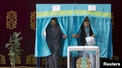 Избиратели выходят из кабинок для голосования в день президентских выборов в Казахстане. Алматинская область, 26 апреля 2015 года.
