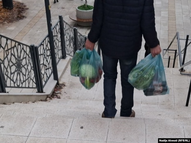 Një qytetar duke u kthyer nga Tregu i Gjelbër në Ulpianë, Prishtinë, pas një dite pazari, 8 dhjetor.