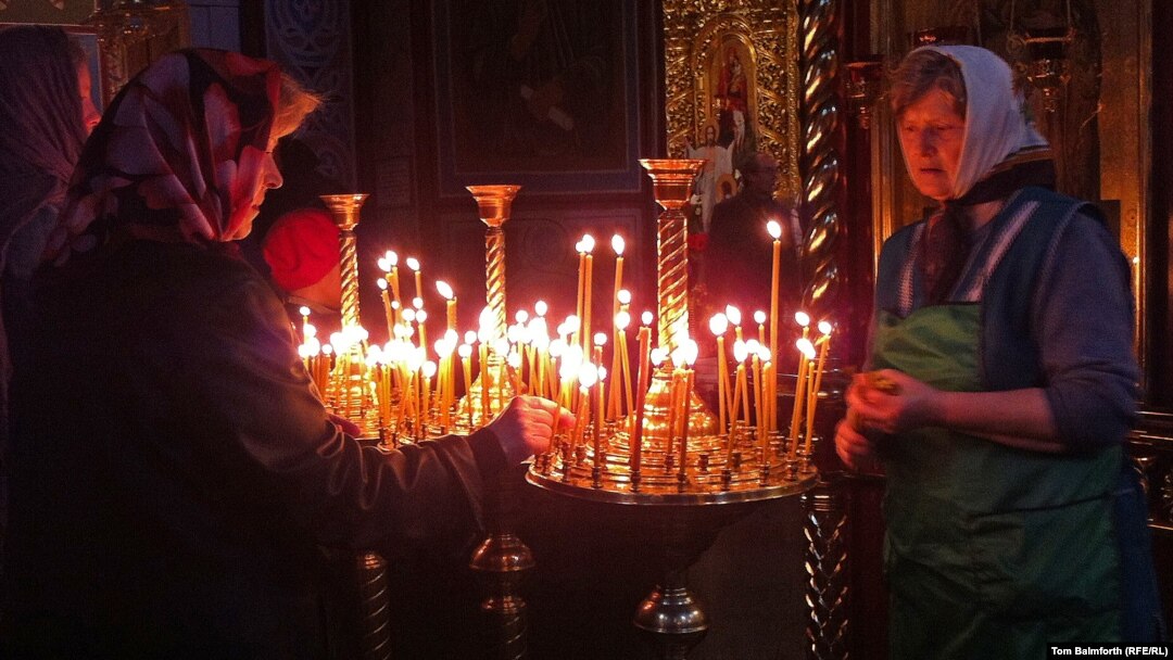 Two elderly women place prayer candles in Kyiv's St. Michael's monastery on Easter Sunday. 
