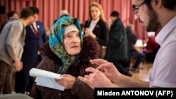 An elderly woman casts her ballot at a polling station during Russia's presidential election in Moscow on March 18.