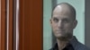 U.S. journalist Evan Gershkovich looks out from inside a glass defendants' cage prior to a hearing at a Russian court in Yekaterinburg on June 26.