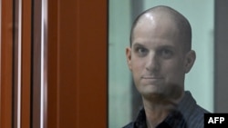 U.S. journalist Evan Gershkovich looks out from inside a glass defendants' cage prior to a hearing at a Russian court in Yekaterinburg on June 26.