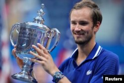 Rusul Daniil Medvedev sărbătorește cu trofeul de campion de la U.S. Open 2021.