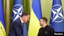 Mark Rutte NATO-főtitkár és Volodimir Zelenszkij ukrán elnök kézfogása közös sajtótájékoztatójuk előtt Kijevben 2024. október 3-án