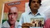 FILE: Indian friends of Kulbhushan Jadhav hold a photograph of them with Jadhav in the neighborhood where he grew up in Mumbai.