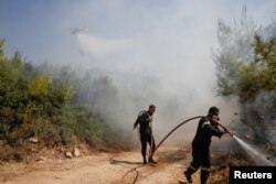 Pompierii, aflați într-o intervenție de stingere a unui incendiu din apropierea satului Rodopoli. Regiunea a mai fost devastată de un incendiu masiv în anul 2018, în urma căruia au murit 102 persoane.