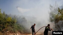Zjarrfikësit në Greqi duke shuar zjarret në afërsi të fshatit Rodopoli, në veri të Athinës. 27 korrik, 2021.
