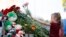 A young girl lays flowers at an impromptu shrine to victims of a deadly school shooting that took place in Tatarstan's capital, Kazan, earlier this week. 