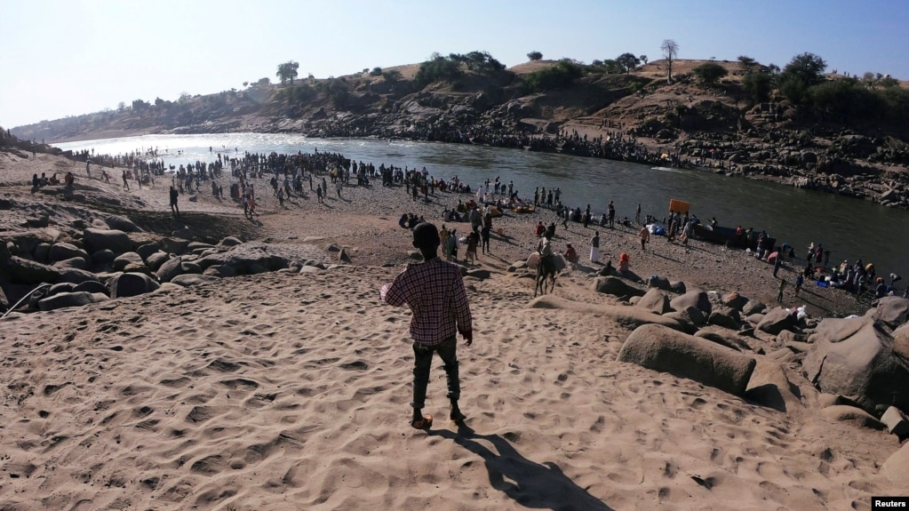 مردمی از اتیوپی که در فرار از جنگ، از رودخانه مرزی سودان و اتیوپی می‌گذرند، ۱۴ نوامبر ۲۰۲۰