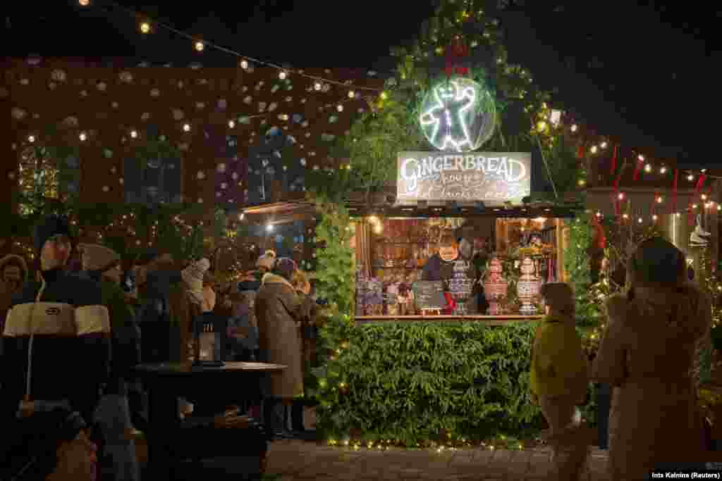 Un comerciant de turte dulci așteaptă clienți la târgul anual de Crăciun din Orașul Vechi din Riga, Letonia, pe 30 noiembrie 2025.