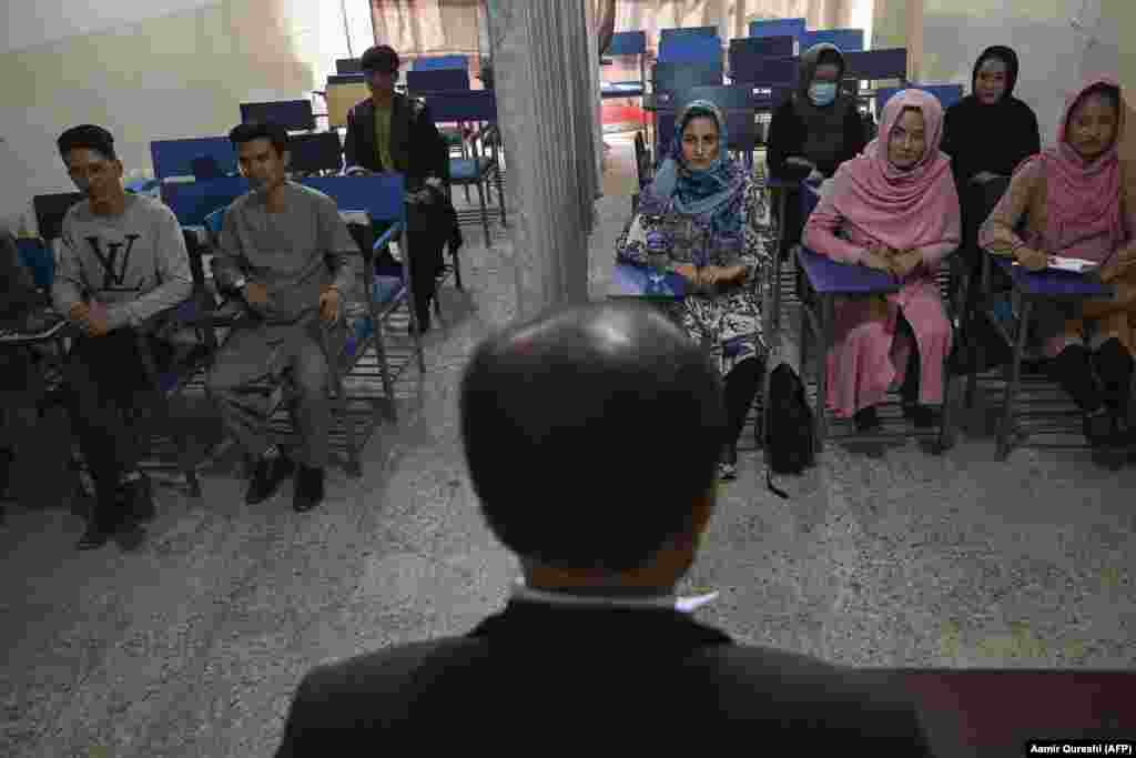 Students attend a class bifurcated by a curtain separating males and females to obey Taliban rulings at a private university in Kabul.