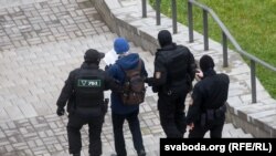 Belarus polisiýasy Minskde tussag edilen protestçini alyp barýar. 15-nji noýabr, 2020 ý.