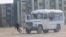 In this still image taken from video acquired by Reuters, a protester runs from a police vehicle on fire in the Kazakh town of Zhanaozen 