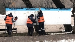 Көшедегі жарнама ілетін тақтаны жөнге келтіріп жатқан жұмысшылар. Алматы, 15 ақпан, 2026 жыл.