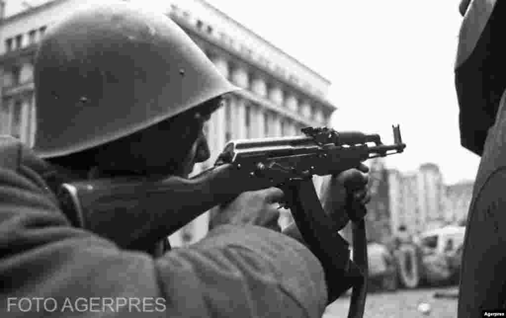 București, 23 decembrie 1989. Soldat cu arma îndreptată spre una din clădirile din Piața Palatului, unde se ascundeau &bdquo;teroriști&rdquo;.&nbsp;