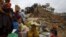 People sit with their belongings outside a damaged temple in Bashantapur Durbar Square after a major earthquake hit Kathmandu, Nepal, on April 25.