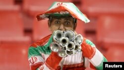 Qatar -- A fan of Iran's Esteghlal cheers for the team during their AFC Championship League soccer match against Qatar's Al-Rayyan in Doha, March 11, 2014. 