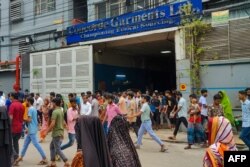 Muncitorii de la una din multele fabrici textile din Dhaka ies la prânz a doua zi după ce prim-ministra Hasina a fugit din țară. În Bangladesh își confecționează hainele mărci arhicunoscute, în condiții care încep să se îmbunătățească, după decenii în care au fost adesea fatale.