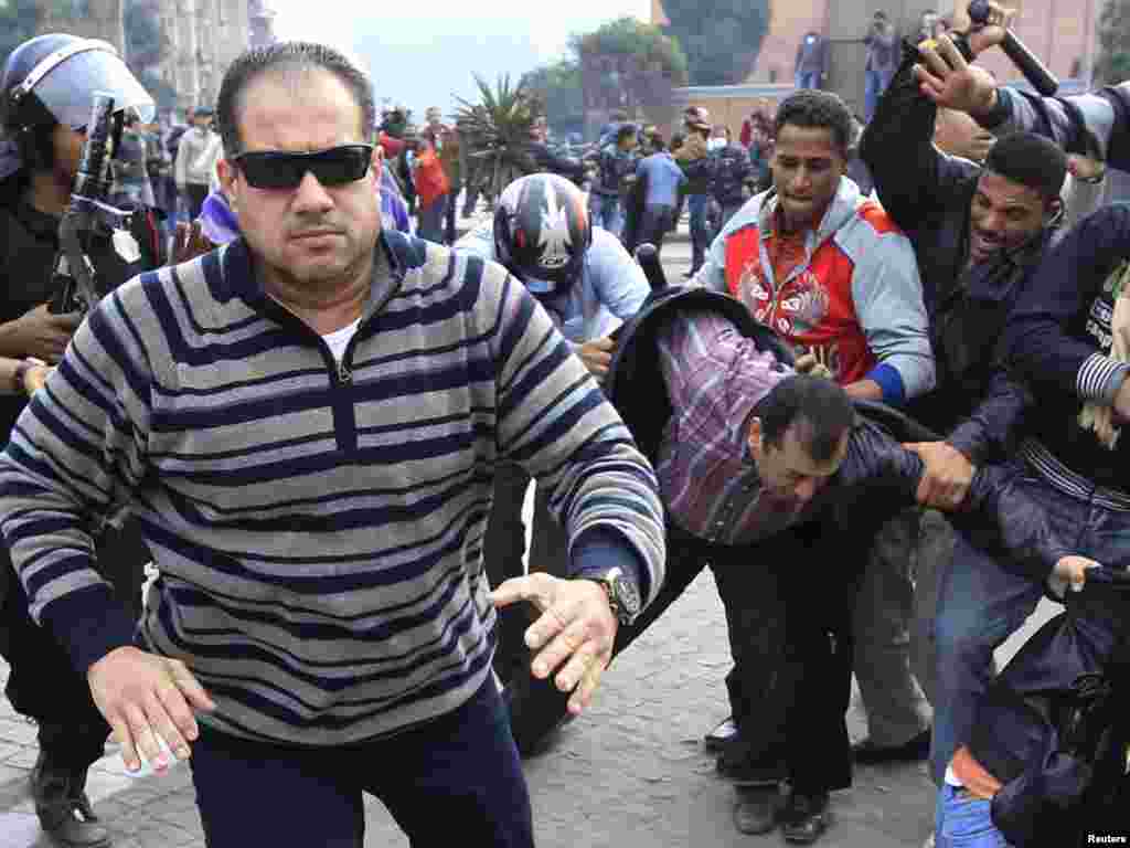 A plainclothes policeman confronts a foreign journalist during a demonstration in Cairo on January 28.