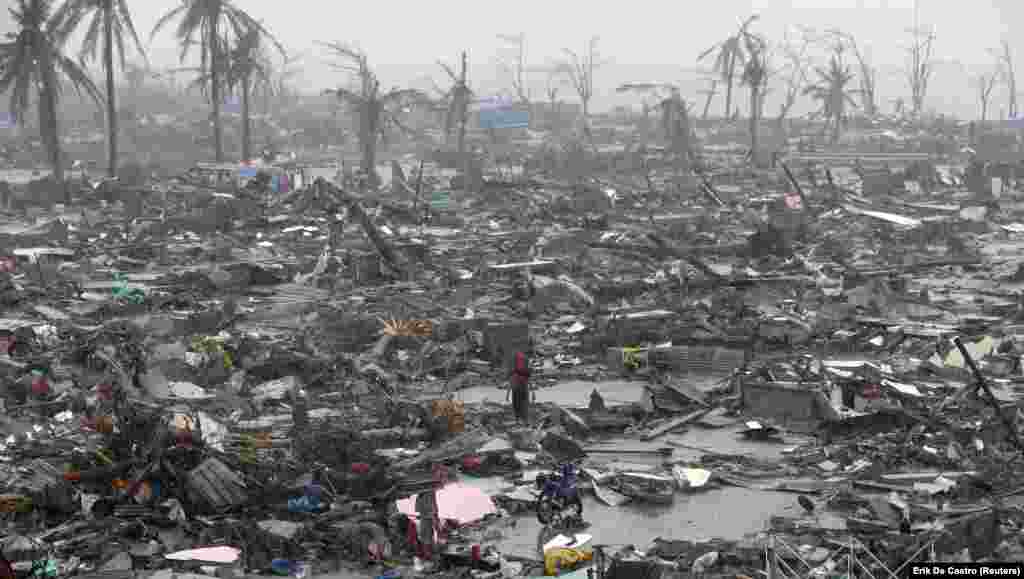 Survivors stand among the ruins of houses after Typhoon Haiyan battered the city of Tacloban in the Philippines on November 10. As many as 10,000 people died as a result of the typhoon, and an estimated 660,000 Filipinos were displaced.