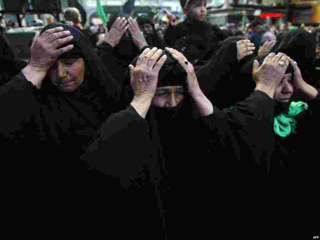 Iraq -- Muslim Shiite women beat their heads in the courtyard of the Imam Abbas Shrine in the southern holy city of Karbala on 02Feb2010 - IRAQ, Karbala : Muslim Shiite women beat their heads in the courtyard of the Imam Abbas Shrine in the southern holy city of Karbala, 110 kms (70 miles) south of the Iraqi capital Baghdad, as they take part in the Shiite mourning day of Arbaeen, on February 2, 2010. The Arbaeen religious event marks the end of 40 days of mourning after the Ashura anniversary that commemorates the seventh century killing of the grandson of Prophet Mohammed, the revered Imam Hussein. Arbaeen will see tens of thousands of Iranian pilgrims pass through Baghdad en route to Karbala to pay homage at the Imam Hussein shrine. AFP PHOTO/MOHAMMED SAWAF POTW05