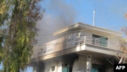 Smoke rises at a branch of the Kabul Bank where Taliban militants detonated a suicide bomb in Lashkar Gah, capital city of Helmand province on December 17.