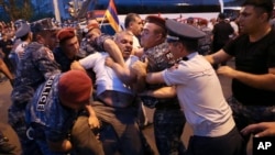 Police detain a demonstrator during an anti-government protest rally in Yerevan on June 3. 