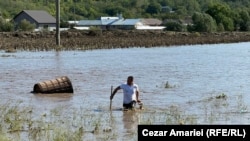 Un localnic din Slobozia Conachi încearcă să recupereze o cuvă din lemn.