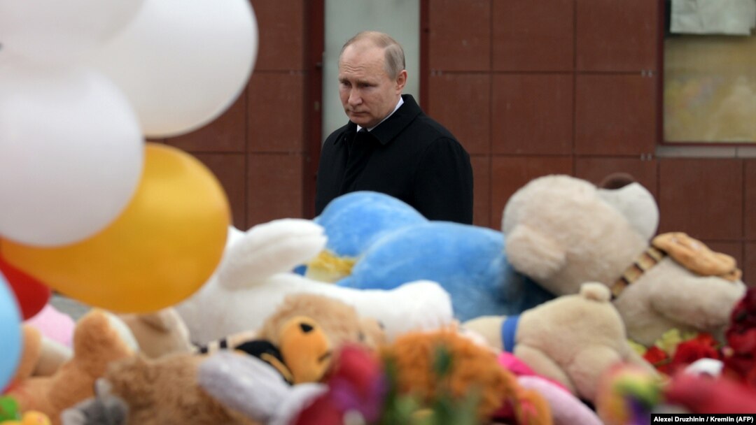 Russian President Vladimir Putin lays flowers in tribute to the victims of a fire at a shopping center in Kemerovo, a disaster that appears to have dented his poularity.