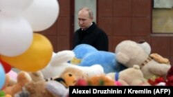 Russian President Vladimir Putin lays flowers in tribute to the victims of a fire at a shopping center in Kemerovo, a disaster that appears to have dented his poularity.