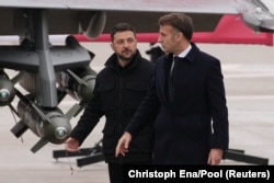 French President Emmanuel Macron (right) and Ukrainian President Volodymyr Zelenskyy walk near a Rafale jet at an air base near Paris in November 2025.