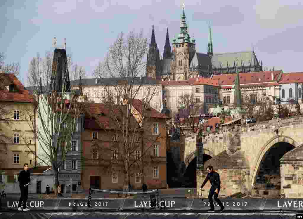 Swiss player Roger Federer (right) plays tennis with Czech Tomas Berdych as they pose for photographers on a boat on the Vltava River during a promotional event for the Laver Cup tennis tournament near the Charles Bridge in Prague. (epa/Martin Divisek)