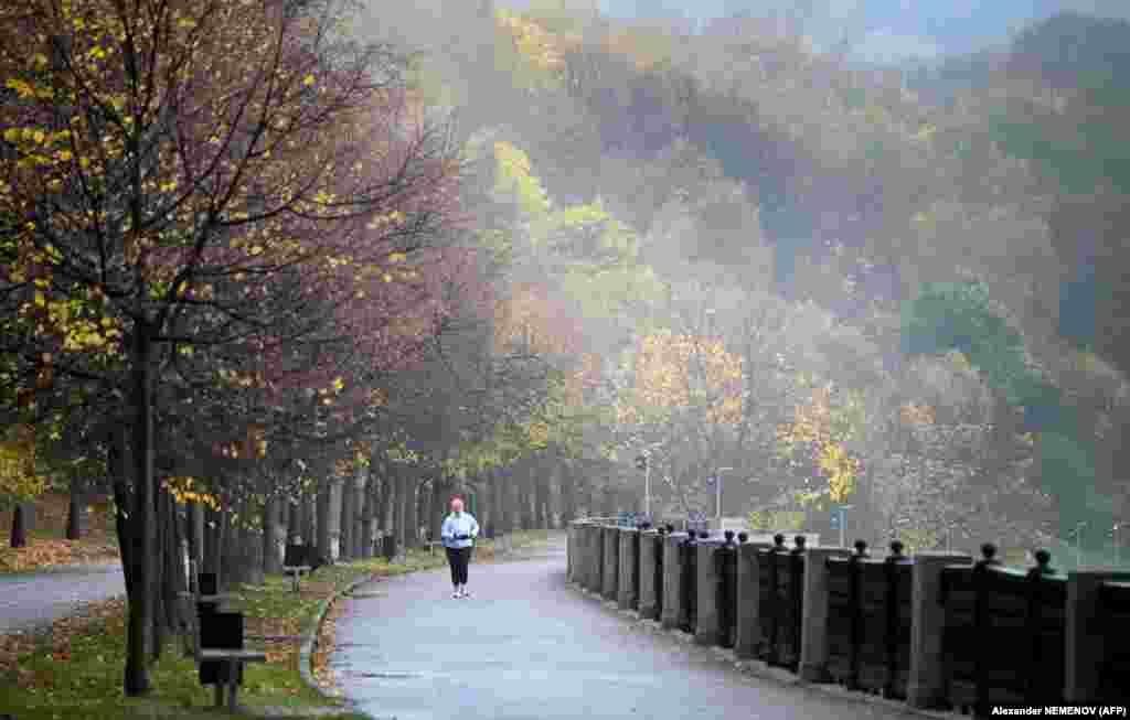 A woman runs along an embankment of the Moskva River in Moscow on October 16. (AFP/Alexander Nemenov)