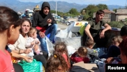 Refugees from Nagorno-Karabakh sit in the back of a truck upon their arrival in the border village of Kornidzor, Armenia, on September 27.