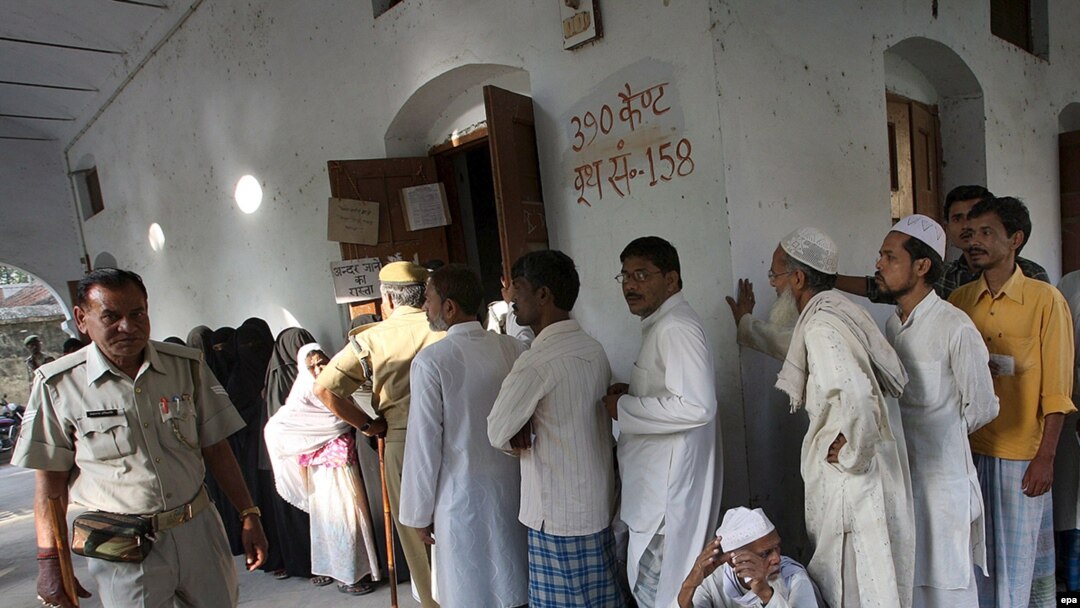 Voters wait outside a polling station in Varanasi.