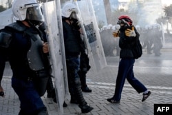 Një protestues duke u ballafaquar me një njësit policor gjatë protestës së 17 tetorit në Tiranë.