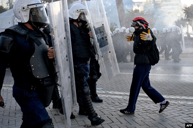Një protestues duke u ballafaquar me një njësit policor gjatë protestës së 17 tetorit në Tiranë.