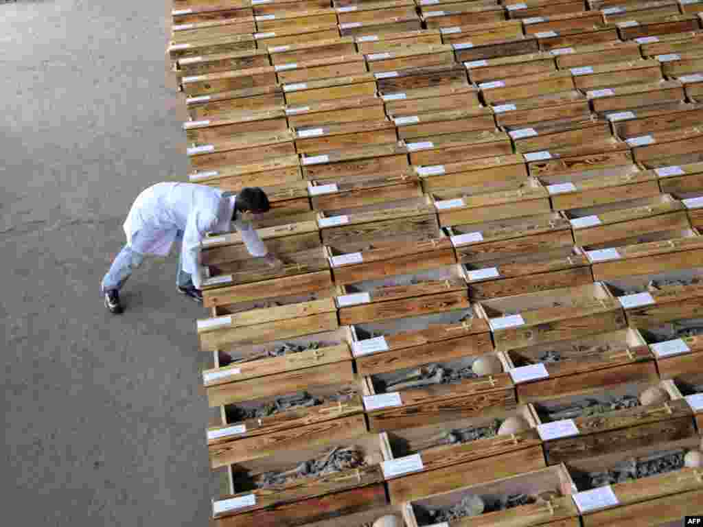 A criminal investigator studies the remains of people found during excavations near Lviv on November 23. - The remains of some 600 people, who were killed by Stalin's secret police or died of starvation trying to escape from the western regions of the country in 1945-1946, were found at Pidzamche near the western Ukrainian city of Lviv. Photo by Yuriy Dyachyshyn for AFP 