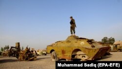 An Afghan soldier stands in a junkyard of Soviet-era tanks in Kandahar in February 2018.